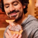 Lächelnder Mann verkostet Schokolade mit Waffel